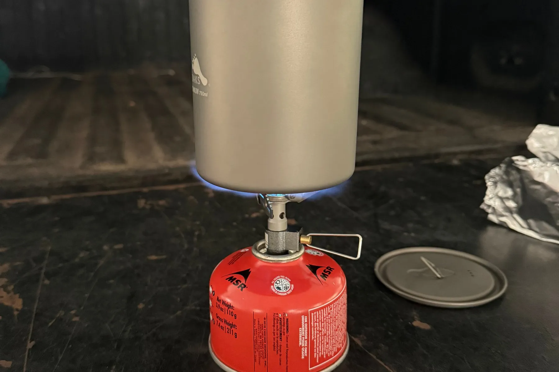 The BRS-3000T lit under a titanium pot, boiling water on an MSR fuel canister